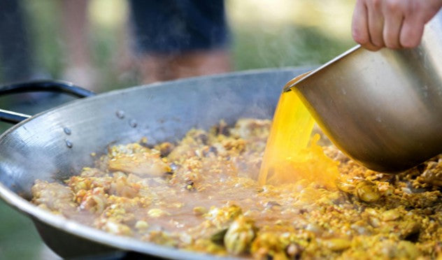 Agregando caldo de mariscos a paella gourmet de ZeQueda Paellas en Bogotá